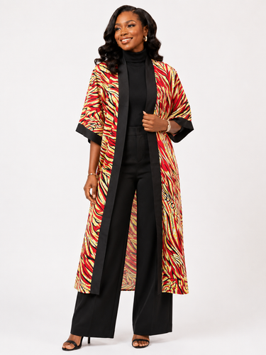 Woman wearing a colorful patterned coat over a black outfit on a white background