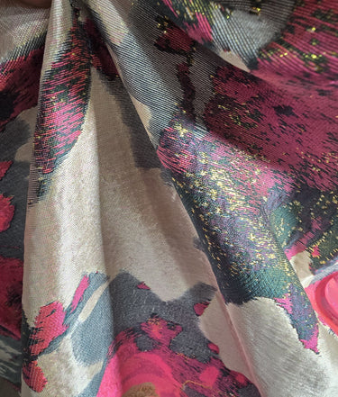 Close-up of patterned fabric with pink, black, and gold colors.