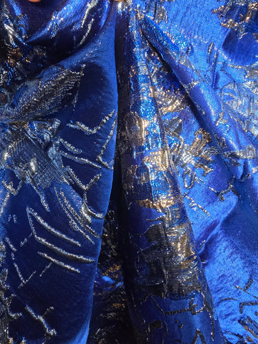 Close-up of blue fabric with silver floral patterns