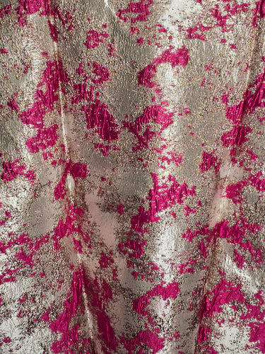 Close-up of a fabric with pink floral pattern on a beige background