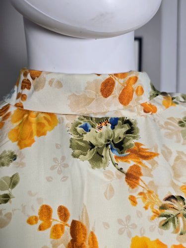 Floral dress with orange and green pattern on a mannequin