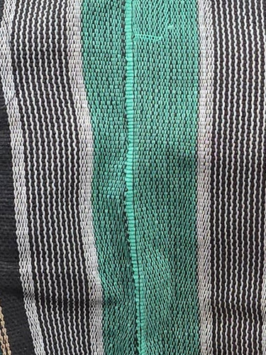 Green sequined dress with striped pattern on a mannequin in a store setting