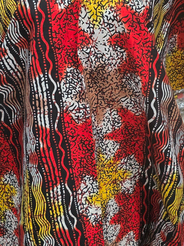 Colorful fabric on a mannequin in a store setting with shelves in the background
