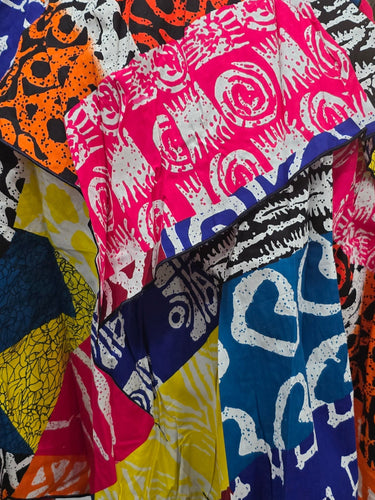 Colorful patterned fabric draped over a surface with shelves in the background