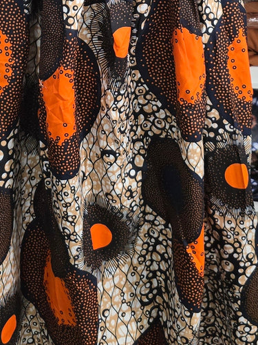 Mannequin wearing a patterned dress in a storage room with shelves filled with various items.