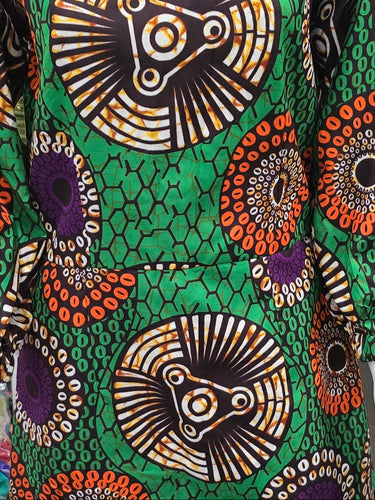 Close-up of vibrant African fabric with intricate patterns on a green background