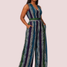 Woman wearing a patterned jumpsuit on a plain background