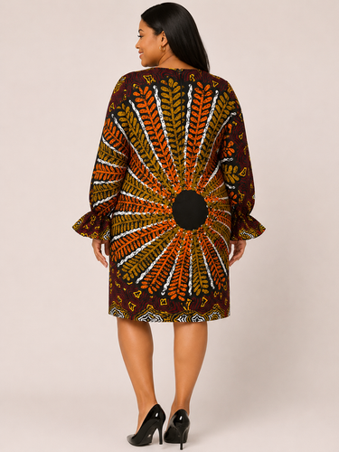 Woman wearing a patterned dress with long sleeves on a plain background