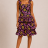 Woman wearing a sleeveless dress with a floral pattern on a beige background