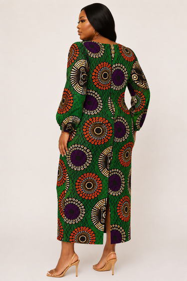 Full length view of a bold green African print maxi dress with large scale Ankara circle medallion motifs in orange purple and gold on a green honeycomb base fabric with fitted long sleeves