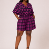 Woman wearing a purple and pink patterned outfit on a white background