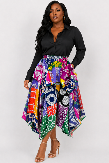 Full length view of a bold multicolor African print patchwork skirt featuring mixed Ankara motifs in purple green orange navy magenta and yellow with a dramatic flowing handkerchief cut asymmetric hem