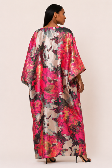 Woman wearing a colorful floral kimono-style dress on a plain background