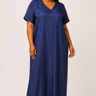 Plus size model wearing a deep navy blue silk weight button down maxi dress with V neckline short flutter sleeves full length button front closure and relaxed A line silhouette styled with nude heeled sandals against a light background
