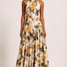 Woman wearing a floral halter neck dress against a plain background