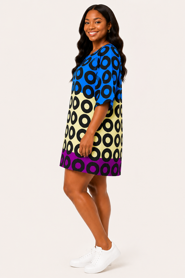 Woman wearing lightweight blue geometric Ankara shift dress with white sneakers