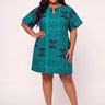 Plus size model wearing a bold teal and black geometric Ankara print short shift dress with keyhole neckline short flutter sleeves and A line silhouette styled with black strappy heeled sandals against a white background