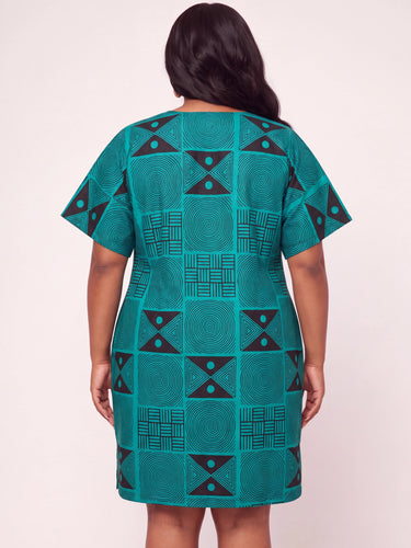 Full length view of a teal and black African print short dress featuring a structured geometric Ankara pattern with spiral circles triangle motifs and basket grid designs in a relaxed plus size A line shift silhouette