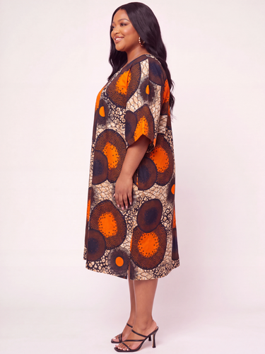 Plus size orange Ankara circle print kaftan midi dress with V neck front open back cutout wide kimono sleeves and relaxed fit in bold African medallion print fabric perfect for brunch wedding guest and casual occasion outfits