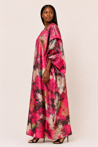 Woman wearing a vibrant, floral-patterned dress on a plain background